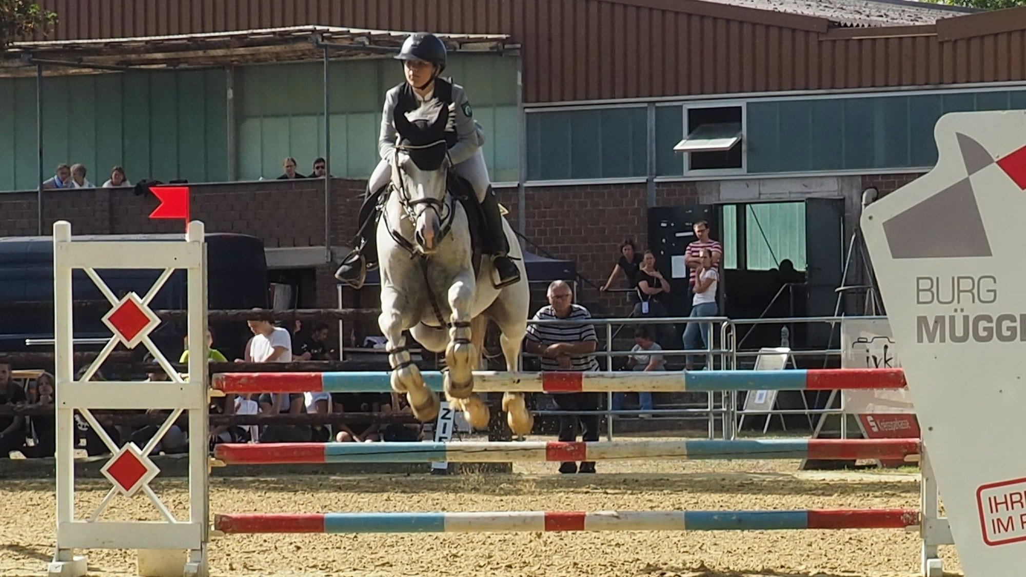 Das Bild zeigt ein Duo, das gerade über ein Hindernis springt.