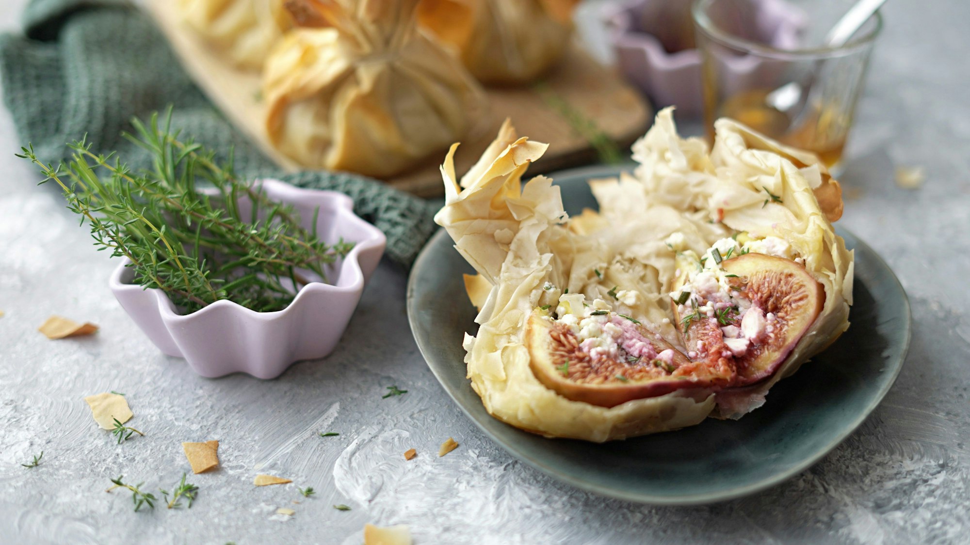 Ein aufgeschnittener Yufka-Beutel mit der gefüllten Feige liegt auf einem Teller.