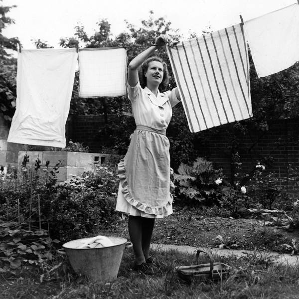 Schwarz-weiß-Foto einer Frau aus dem Jahr 1959, die Wäsche aufhängt.