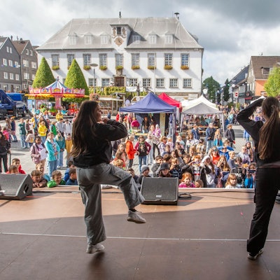 Das Foto zeigt zwei Tänzer und viele Zuschauer.
