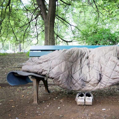 Ein Mann schläft auf einer Bank in einem Park.
