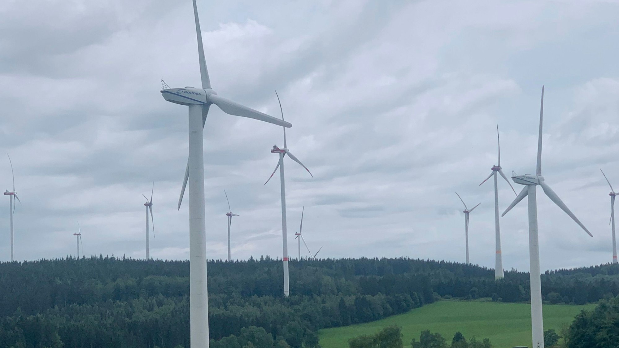 Das Bild zeigt Windenergieanlagen in einem Waldgebiet.