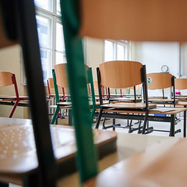 In einem Klassenzimmer stehen die Stühle auf den Tischen.