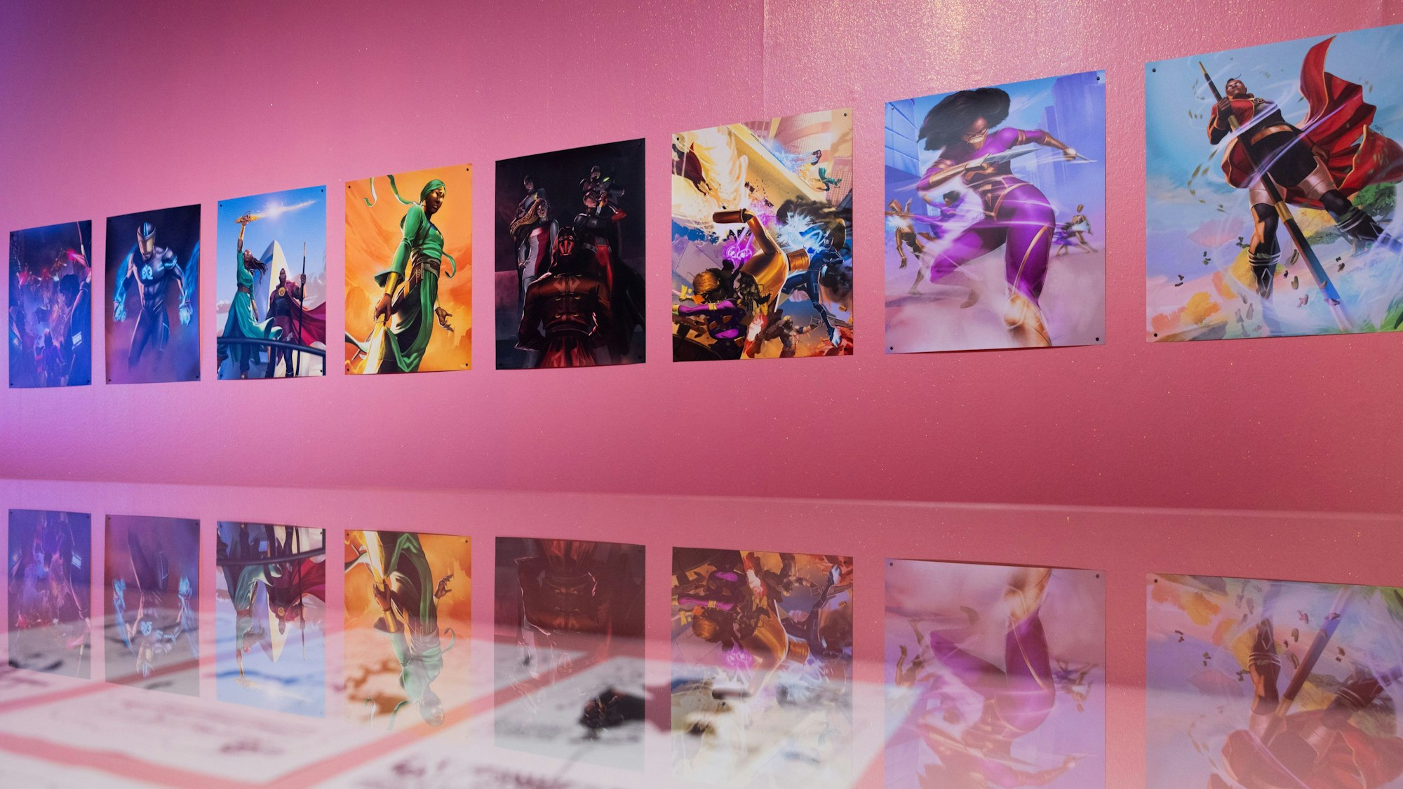 An einer pinken Wand hängen Zeichnungen von Superhelden.