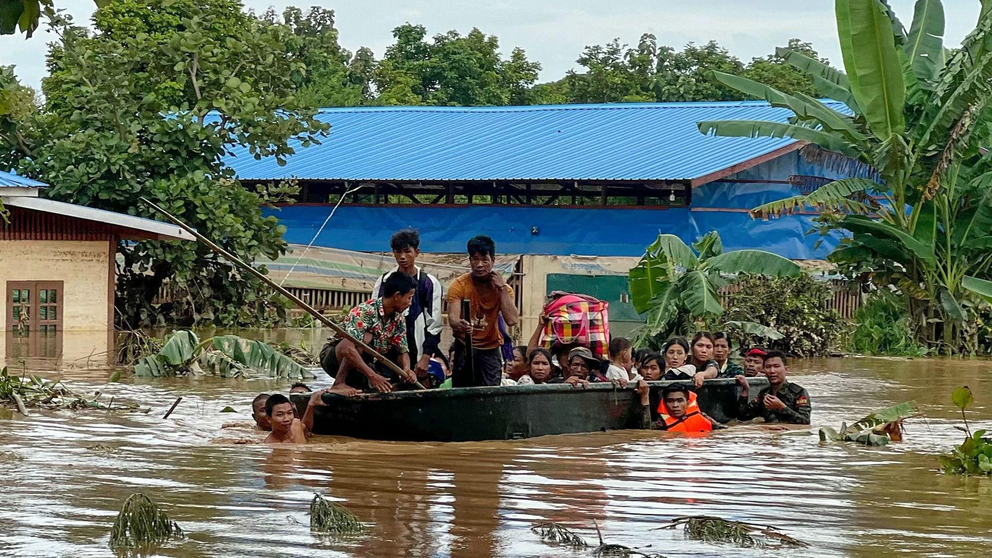 Bewohner von Pyinmana in Myanmar werden in einem Rettungsboot durch die überschwemmten Straßen transportiert.