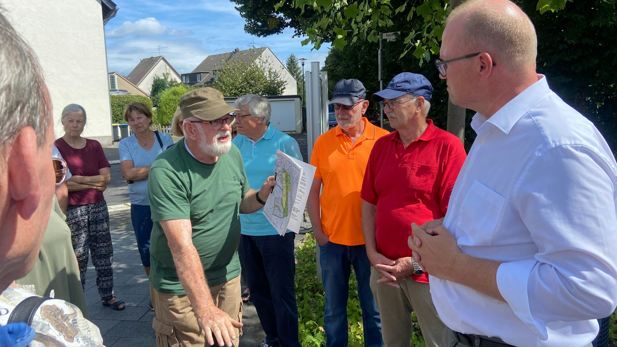 Hans-Gerd Ervens (Mitte) spricht mit Jochen Ott (rechts) und Betroffenen über mögliche Gründe für das Wasserproblem.