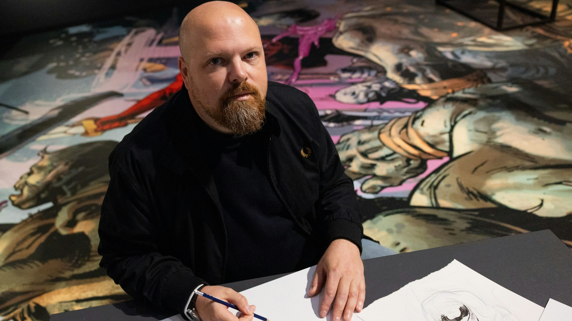 Der Künstler Nic Klein sitzt inmitten seiner Werke.