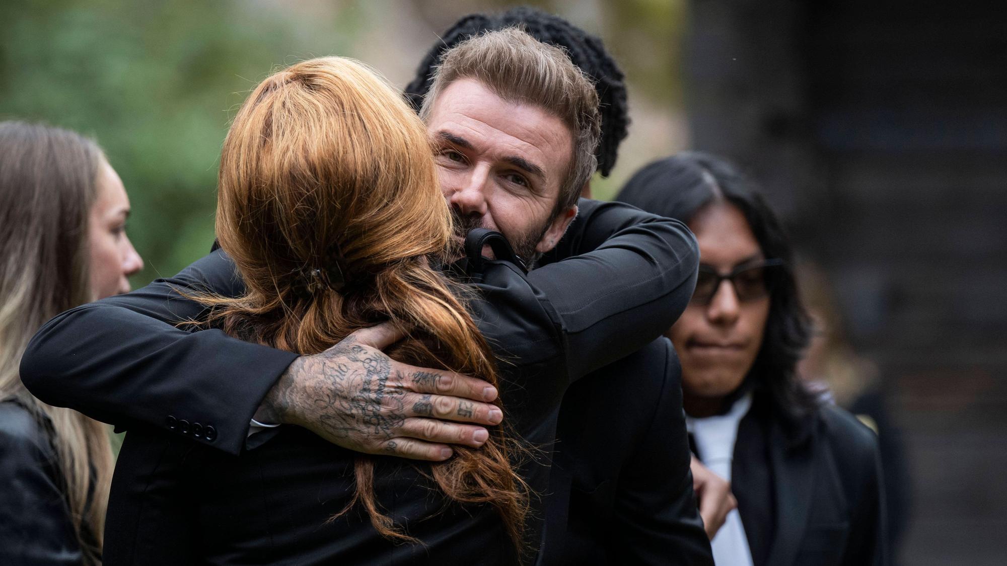 David Beckham umarmt Yaniseth Alcides, die hinterlassene Partnerin von Sven-Göran Eriksson.