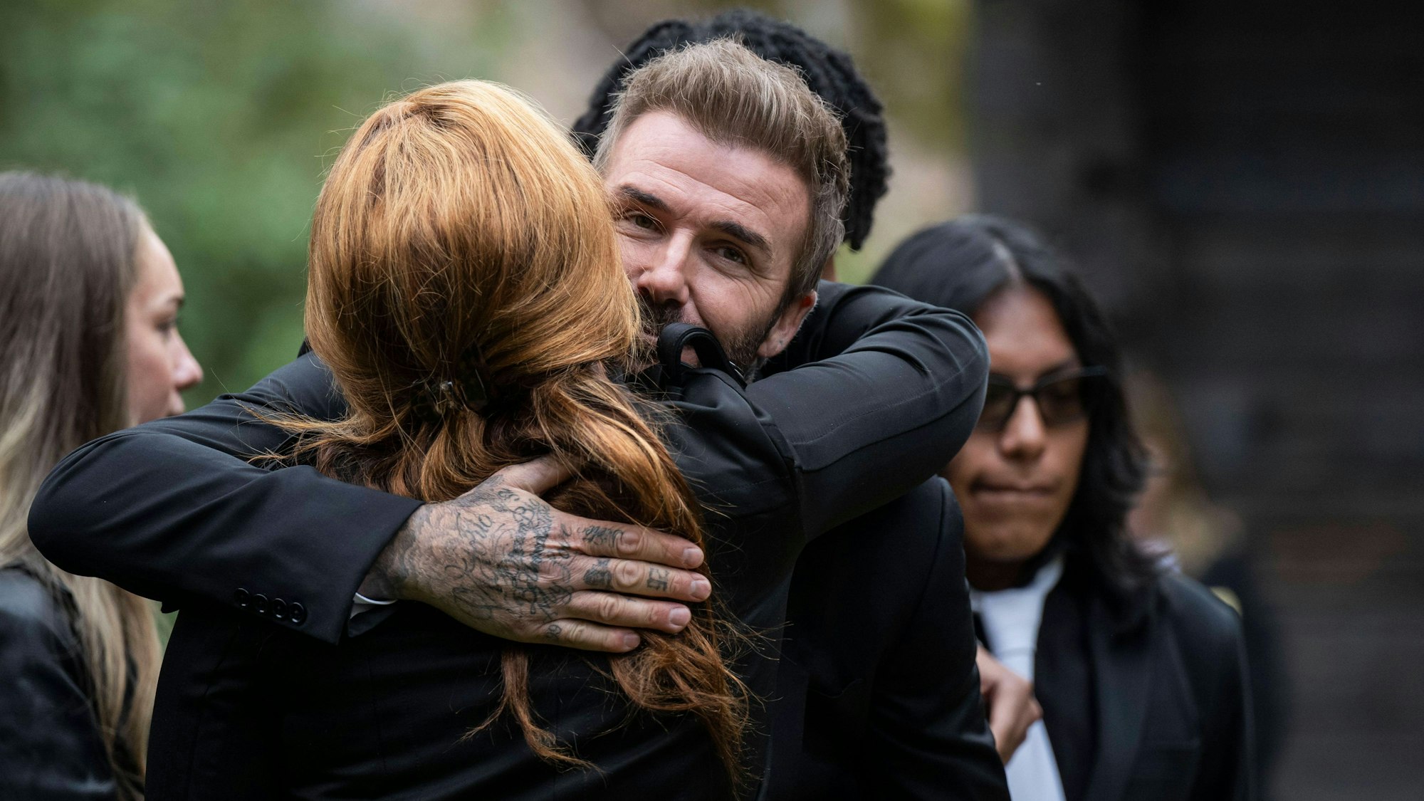 David Beckham umarmt Yaniseth Alcides, die hinterlassene Partnerin von Sven-Göran Eriksson.