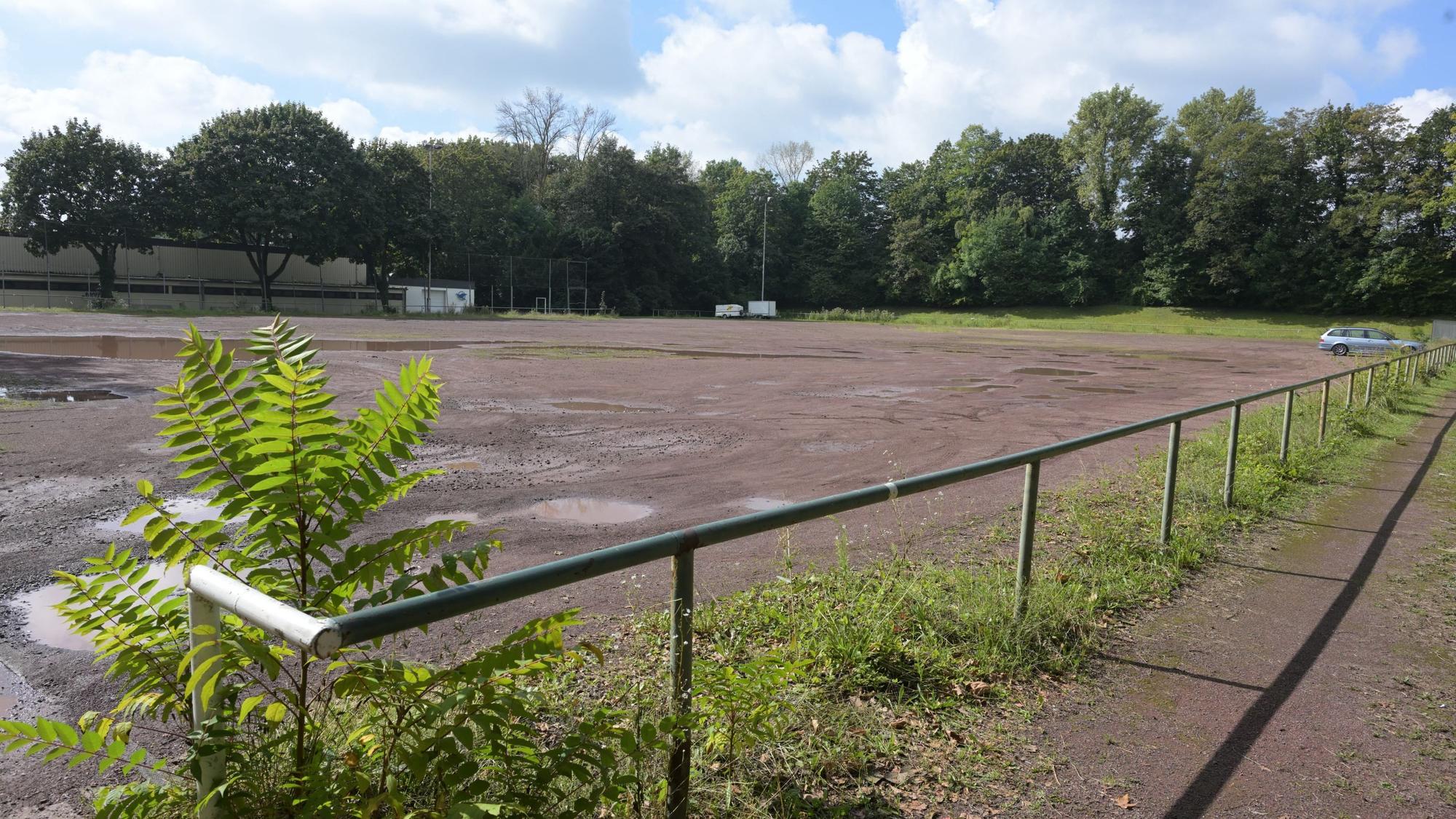 Der Aschenplatz ist zu sehen. Ein Auto parkt dort.