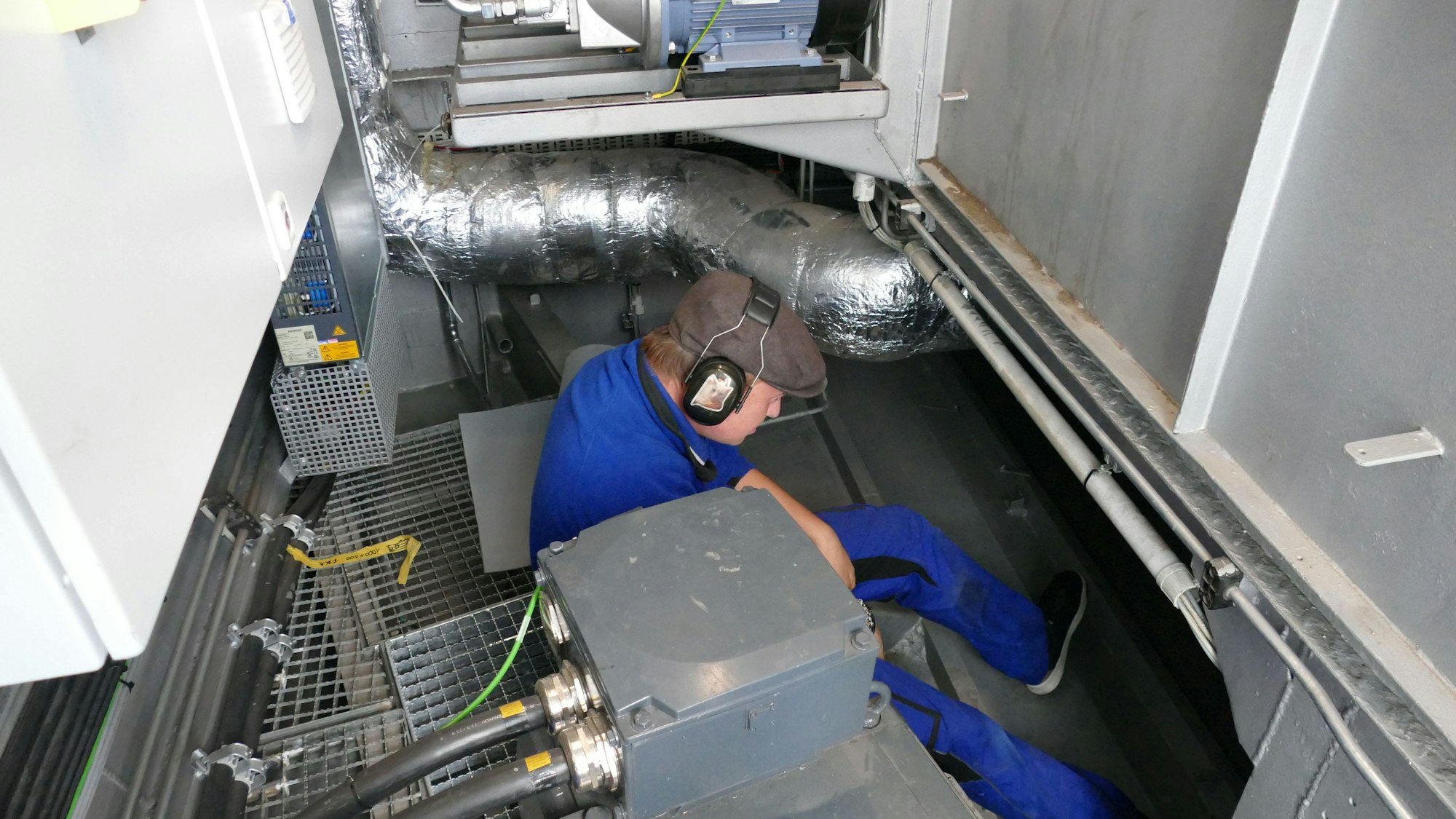 Ein Mann sitzt in einem Maschinenraum.