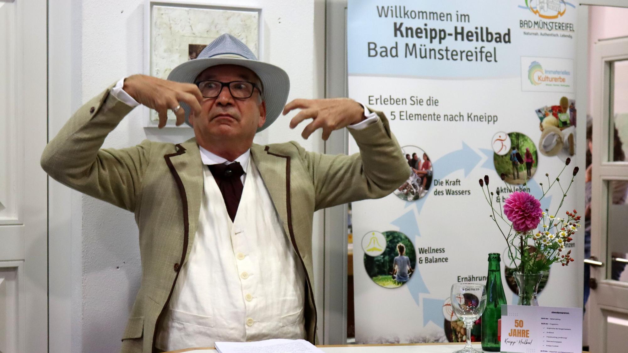 Ein Schauspieler atmet ausladend gestikulierend ein.