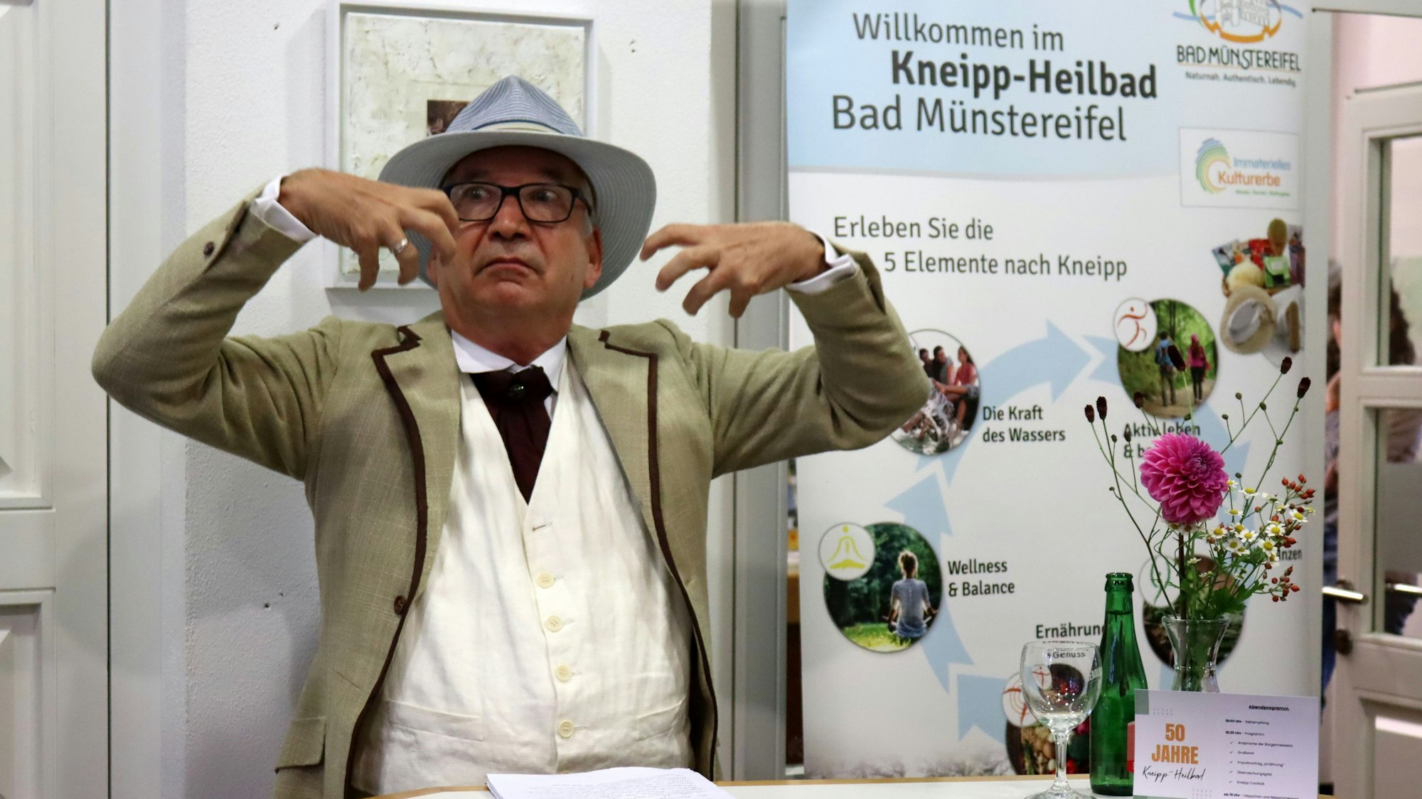 Ein Schauspieler atmet ausladend gestikulierend ein.