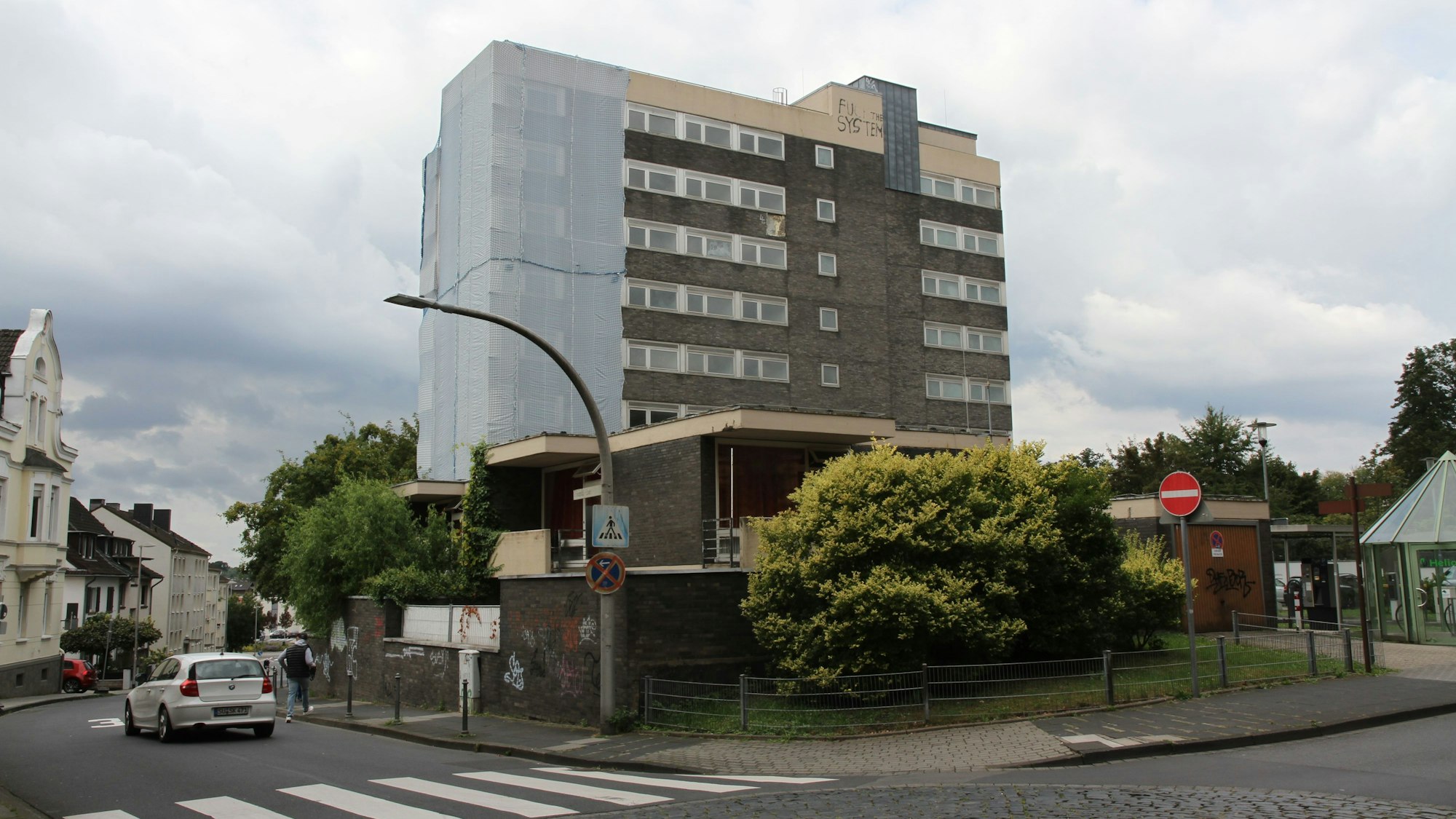 Ein Hochhaus mit einer Schutzplane über dem linken Gebäudeteil.