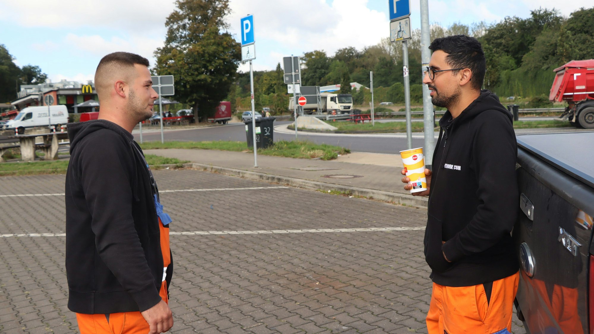 Zwei Männer unterhalten sich am Rastplatz Frechen Süd.