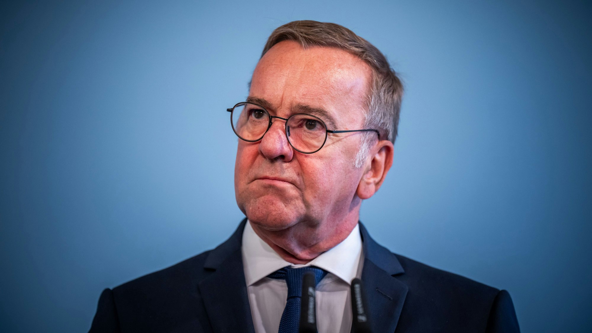 Boris Pistorius nimmt an einem Pressestatement nach der Unterzeichnung des Regierungsabkommen über Stationierung der Litauen-Brigade teil. Er steht vor blauem Hintergrund.