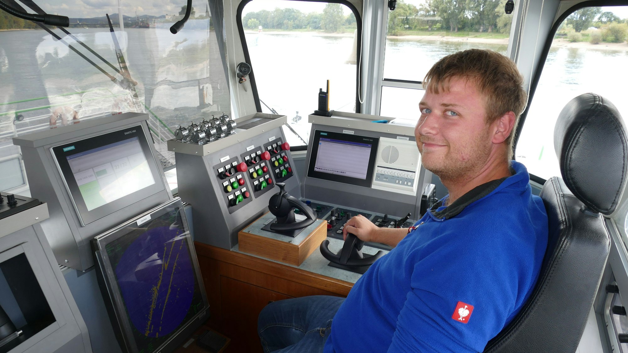 Ein Mann sitzt im Führerhaus einer Fähre.