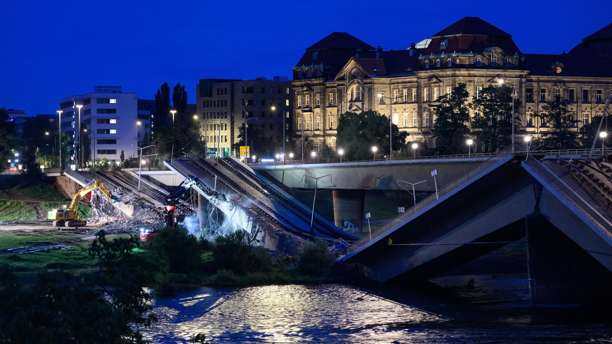 dpatopbilder - 13.09.2024, Sachsen, Dresden: Mit Baggern werden weitere Teile der eingestürzten Carolabrücke abgerissen, dahinter ist die Staatskanzlei zu sehen. Im Zuge von Abrissarbeiten ist ein weiterer Abschnitt der Carolabrücke in Dresden eingebrochen. Es handelt sich um den Brückenstrang mit Straßenbahngleisen, der in der Nacht zum Mittwoch bereits teilweise in die Elbe gestürzt war. Foto: Robert Michael/dpa +++ dpa-Bildfunk +++