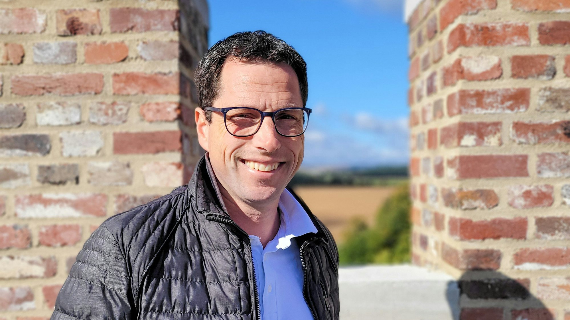 Oliver Hohn, Schriftführer der Hovener Jungkarnevalisten, lehnt in schwarzer Steppjacke und hellem Poloshirt an den Zinnen des Weiertors.