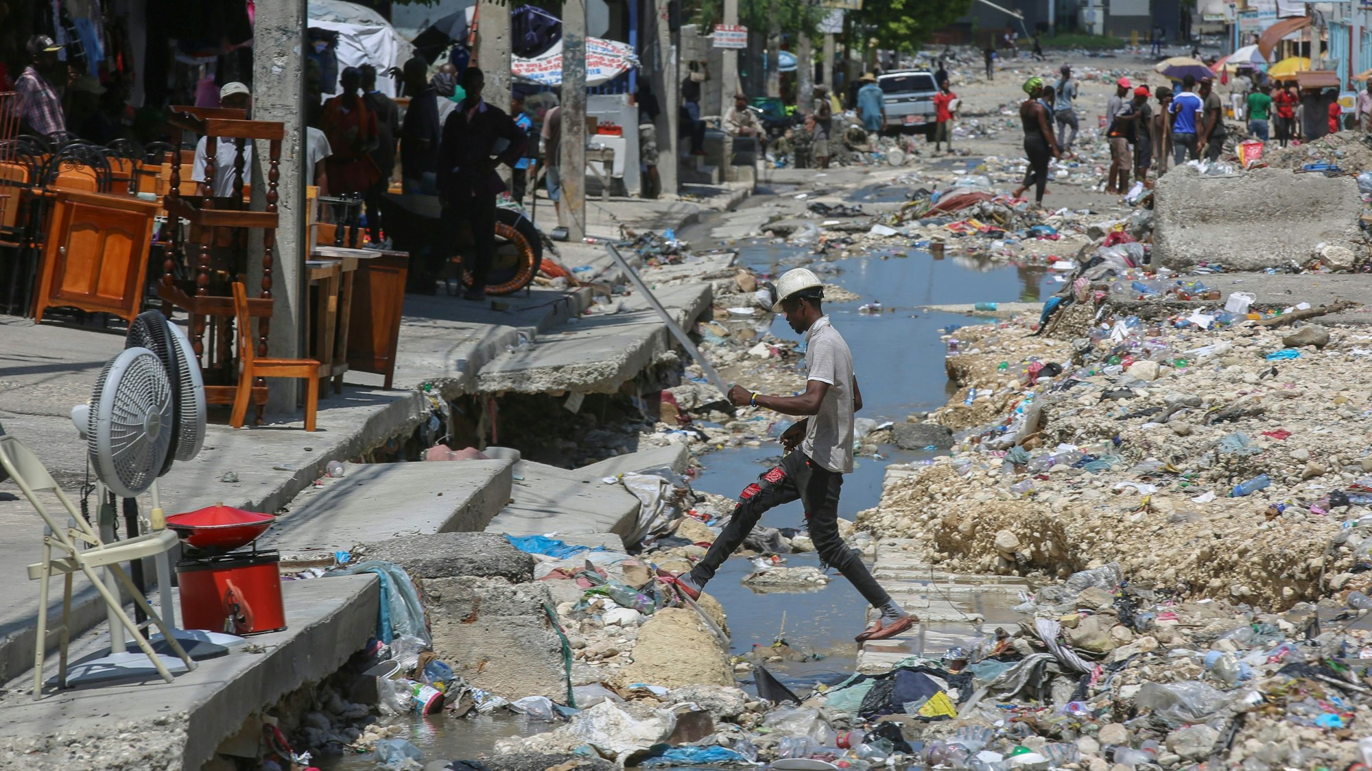 Ein Mann geht nach einem Sturm in Haiti über eine zugemüllte Straße.