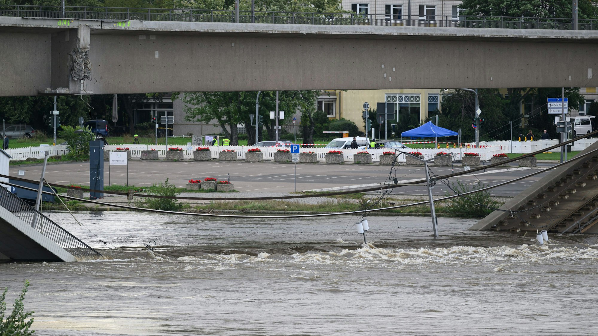 Wasser der Elbe fließt über Brückenteile der eingestürzten Carolabrücke.
