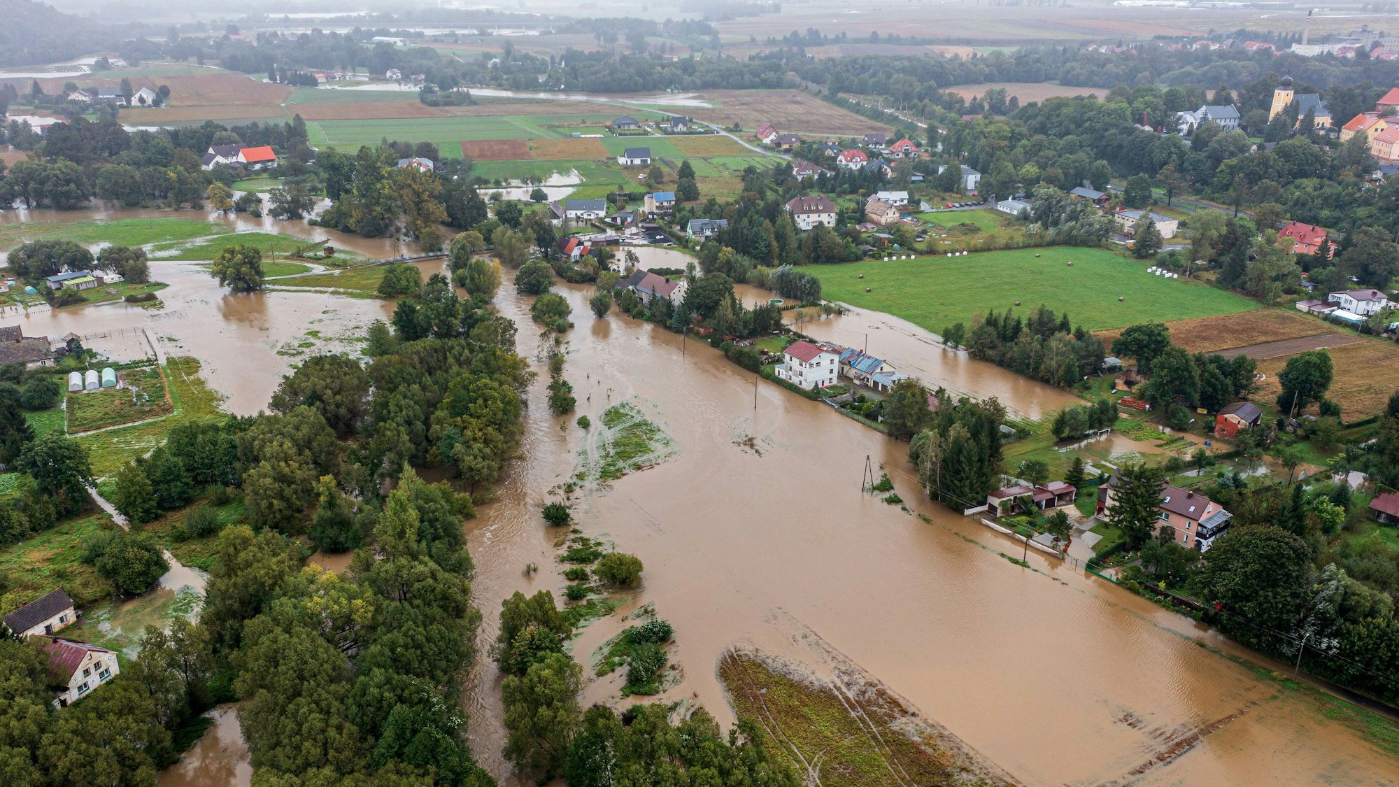 Ein mit einer Drohne aufgenommenes Luftbild zeigt eine überschwemmte Straße nach starkem Regen im Südwesten Polens (Krosnowice).
