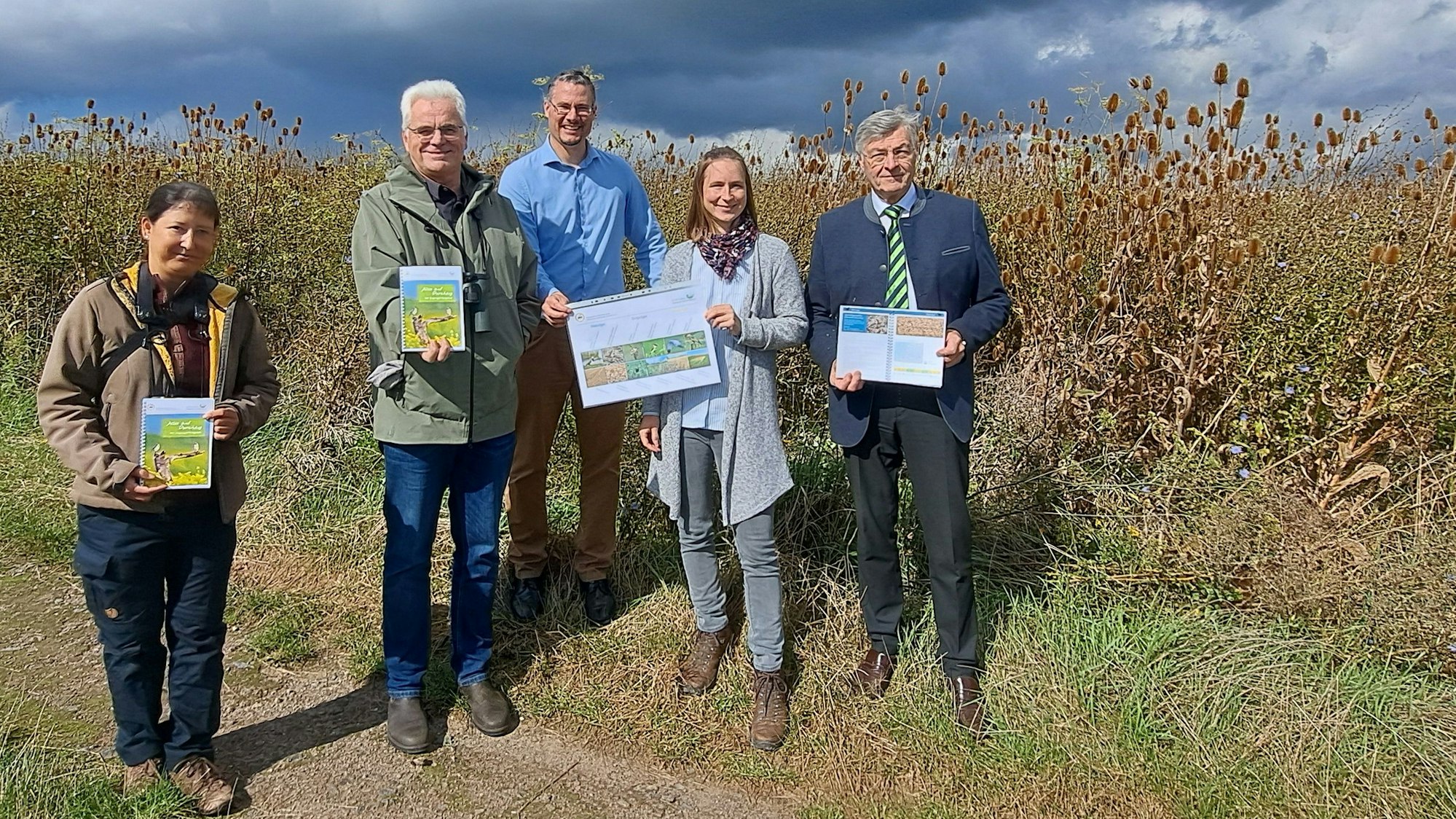 An einem Blühstreifen in Niederkassel-Rheidt stellen Vertreterinnen und Vertreter der Stiftung Rheinische Kulturlandschaft und der Nordrhein-Westfälischen Ornithologengesellschaft den neu erschienenen Zugvogel-Ratgeber "Alles auf Durchzug" vor.