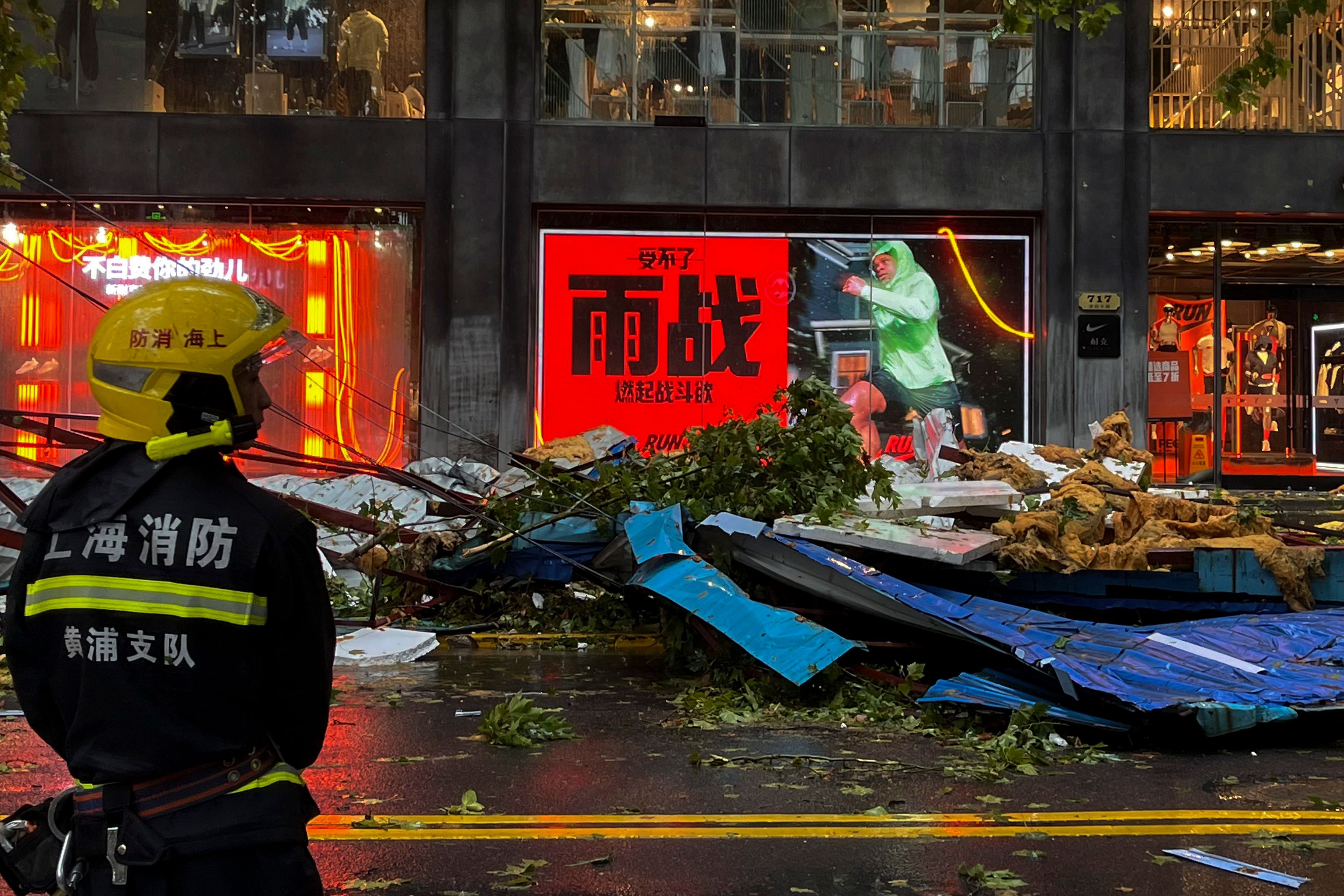 Ein Feuerwehrmann steht vor Trümmern auf einer Straße in Shanghai.