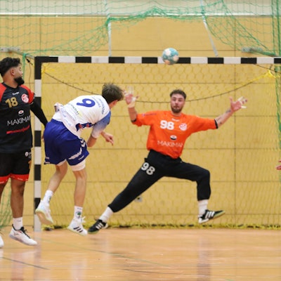 Ein Königsdorfer Angreifer hat auf das Tor geworfen, der Ball ist noch in der Luft. Der Torwart fixiert ihn mit den Augen, um ihn abzuwehren.