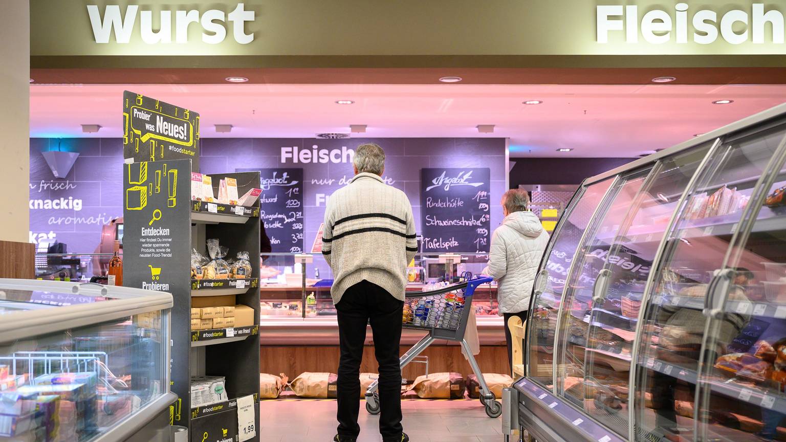 Kunden stehen in einer Filiale von Edeka.