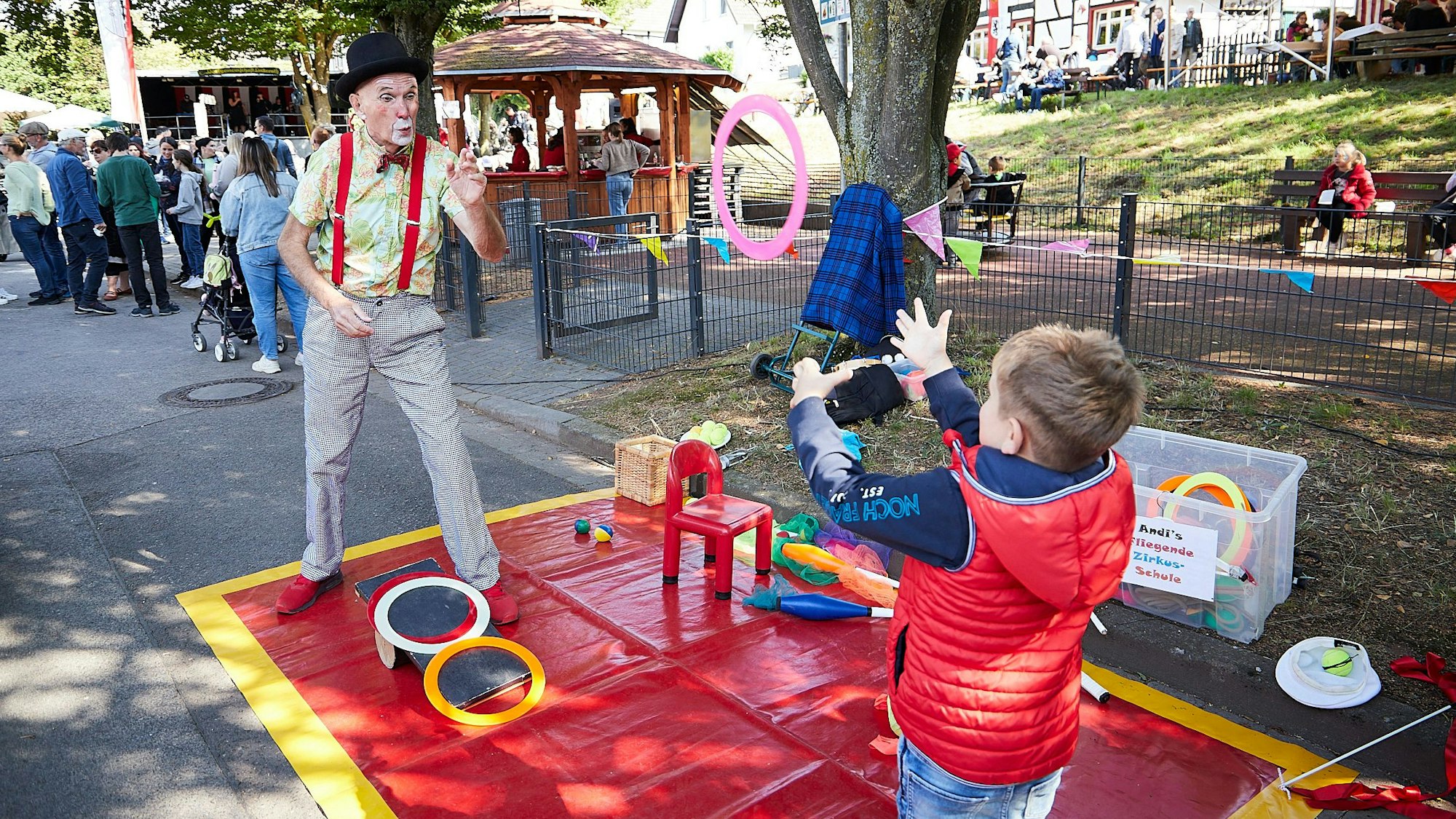 Zauberer Andi zeigt dem Jungen Finn ein Kunststück.
