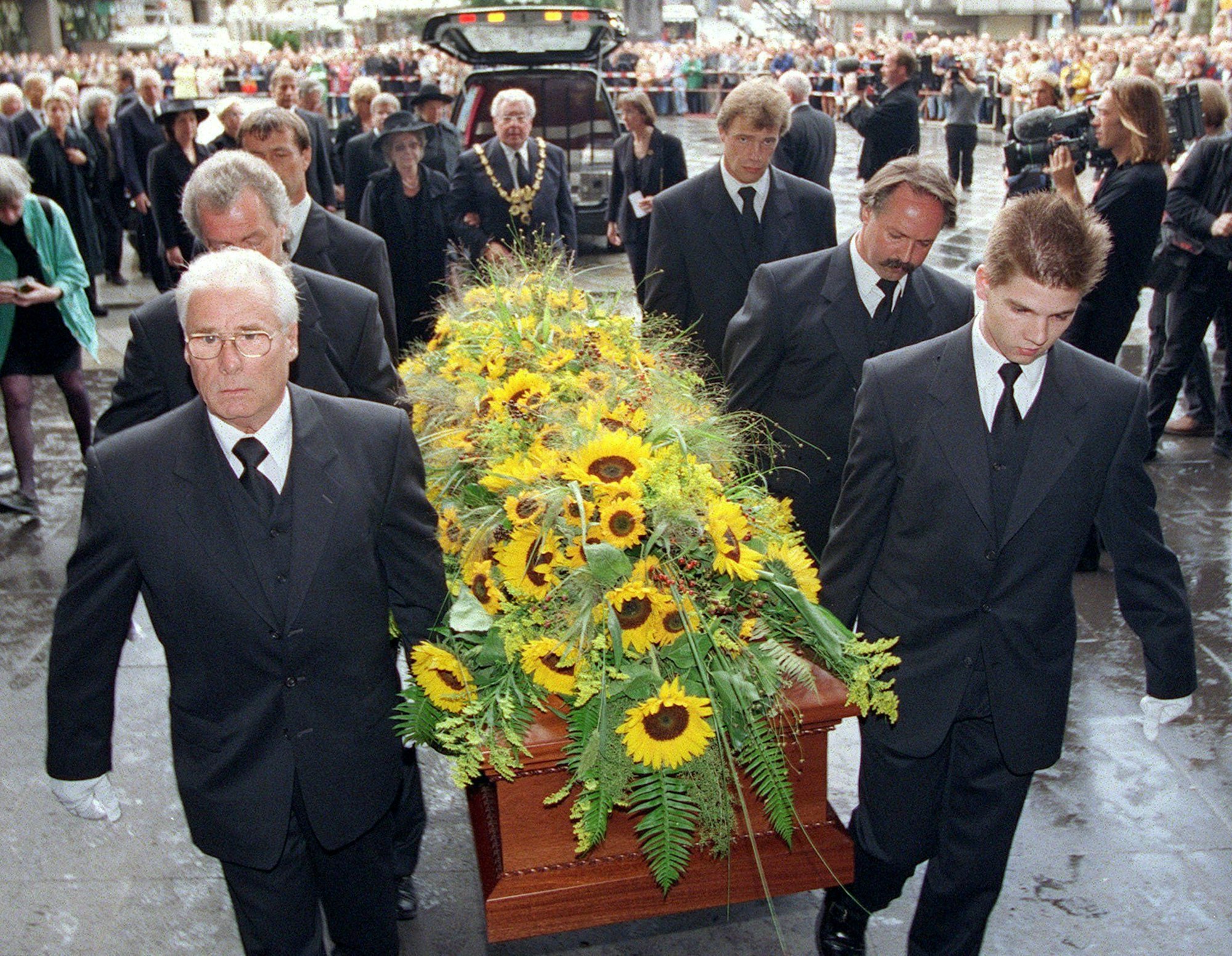 Dem mit Sonnenblumen geschmückten Sarg von Willy Millowitsch folgt seine Witwe, Gerda Millowitsch, am Arm des Kölner Oberbürgermeisters Norbert Burger am Samstag (25.09.1999) in den Kölner Dom.