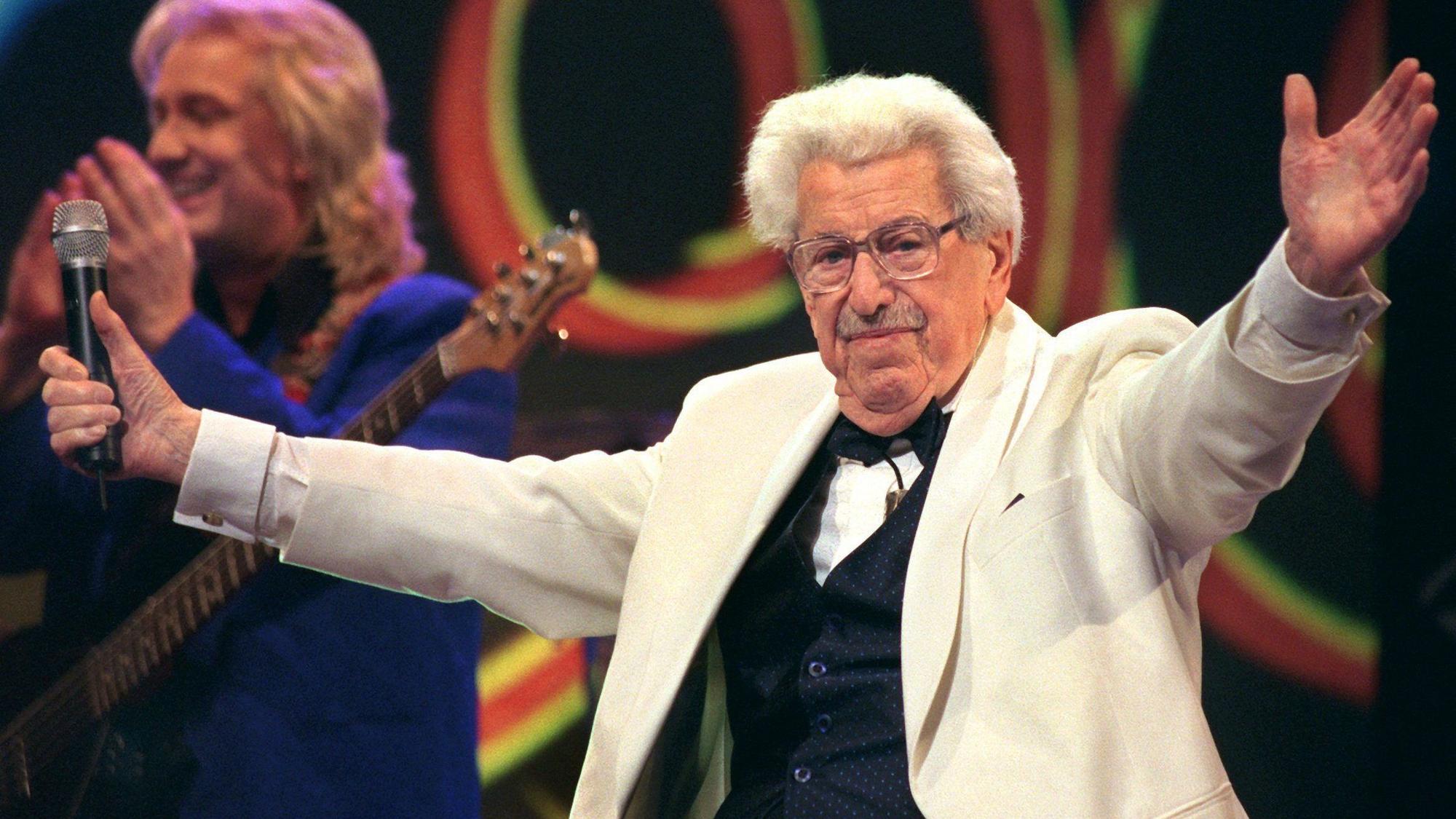 ARCHIV - 08.01.1999, Nordrhein-Westfalen, Köln: 08.01.1999, Nordrhein-Westfalen, Köln: Willy Millowitsch dirigiert während seiner Gesangseinlage die Gäste eines Gala-Abends in der KölnArena.