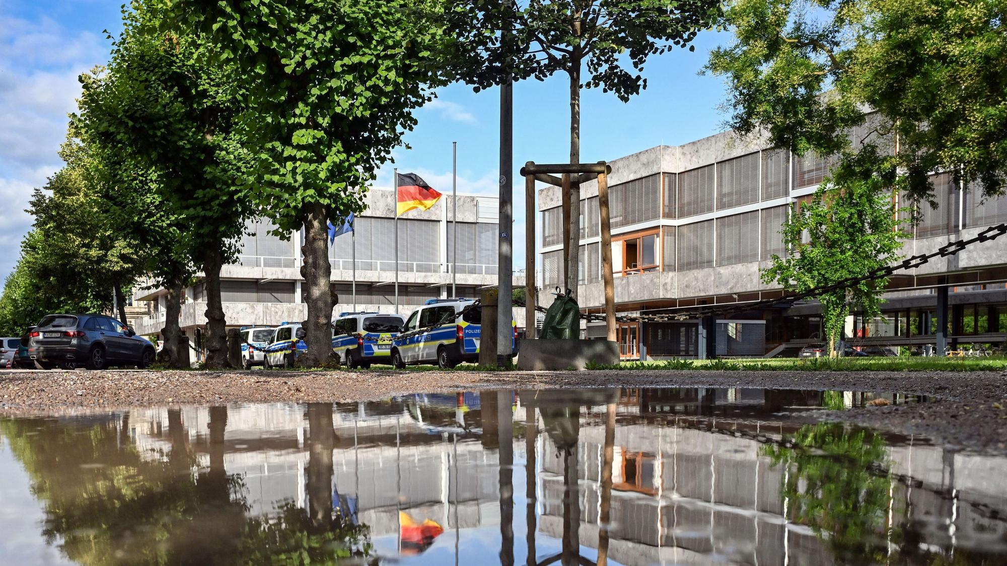 Außenaufnahme des Bundesverfassungsgerichtes, das sich in einer Pfütze spiegelt.