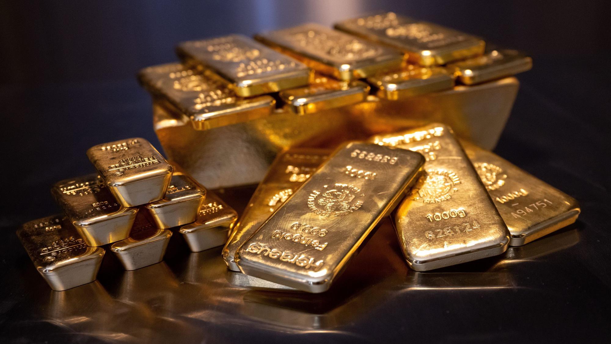 Goldbarren in unterschiedlicher Größe liegen bei einem Edelmetallhändler in einem Tresor auf einem Tisch.