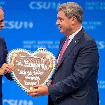 ARCHIV - 23.09.2023, Bayern, München: Friedrich Merz (l), CDU-Vorsitzender, bekommt auf dem Parteitag der CSU von Markus Söder, CSU-Parteivorsitzender, ein Lebkuchenherz mit der Aufschrift ·In Bayern lebt es sich einfach besser!· geschenkt. (zu dpa: «K-Frage der Union: Bayern wollen viel lieber Söder als Merz») Foto: Peter Kneffel/dpa +++ dpa-Bildfunk +++