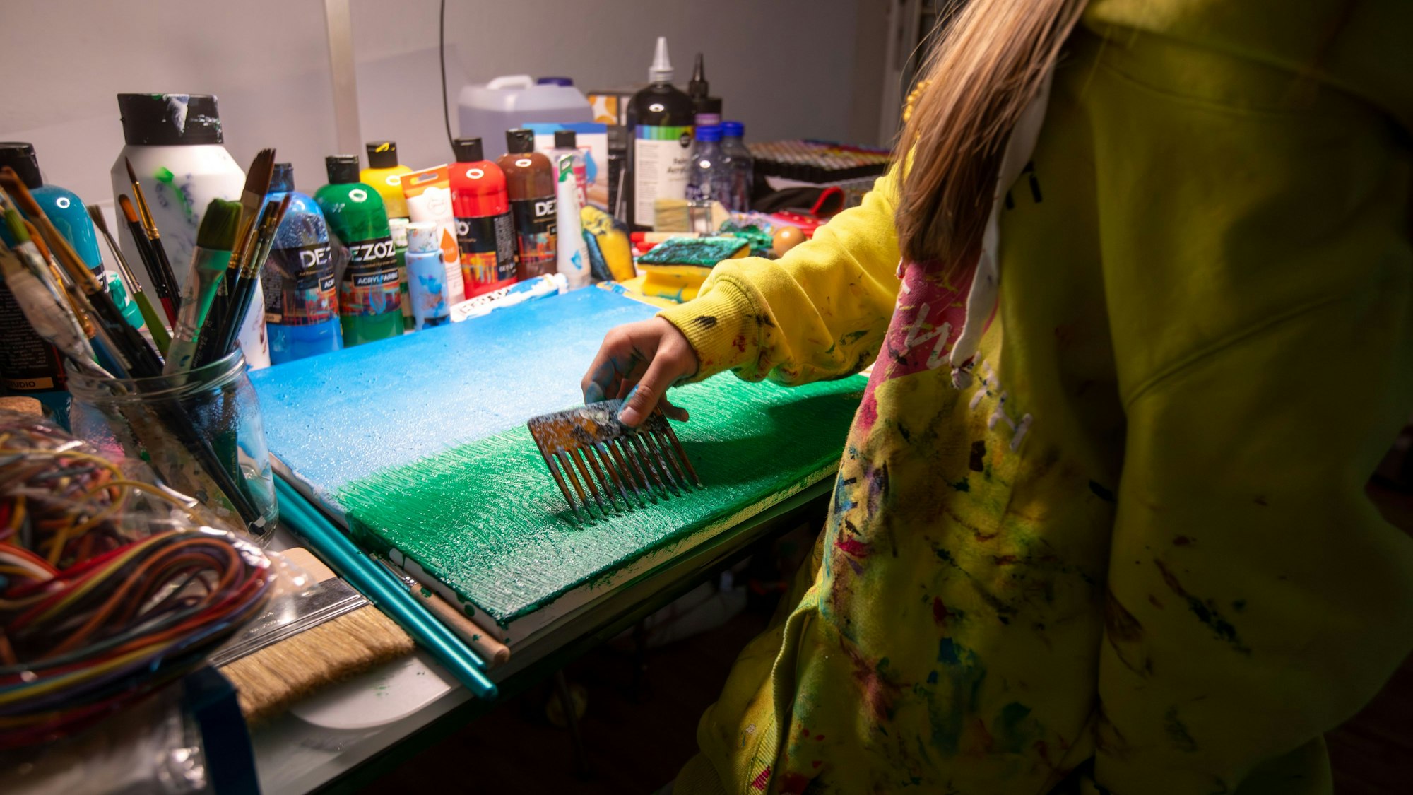 Die elfjährige Carolina Neubauer malt an einem Tisch in der Wohnung.