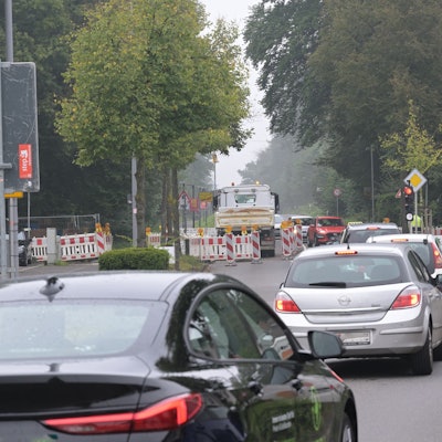 Vor der Baustellenampel stehen Autos im Stau.