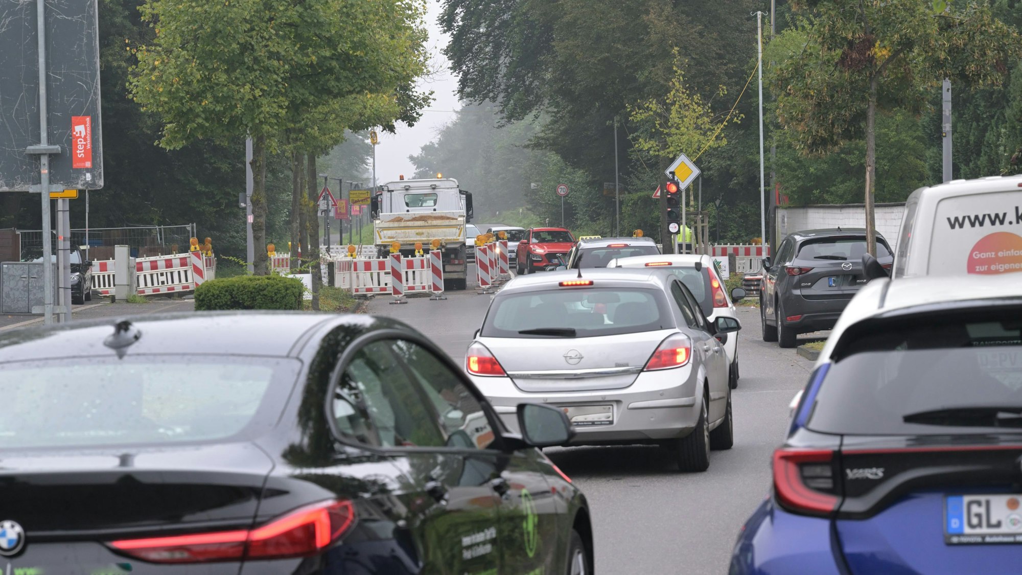 Vor der Baustellenampel stehen Autos im Stau.