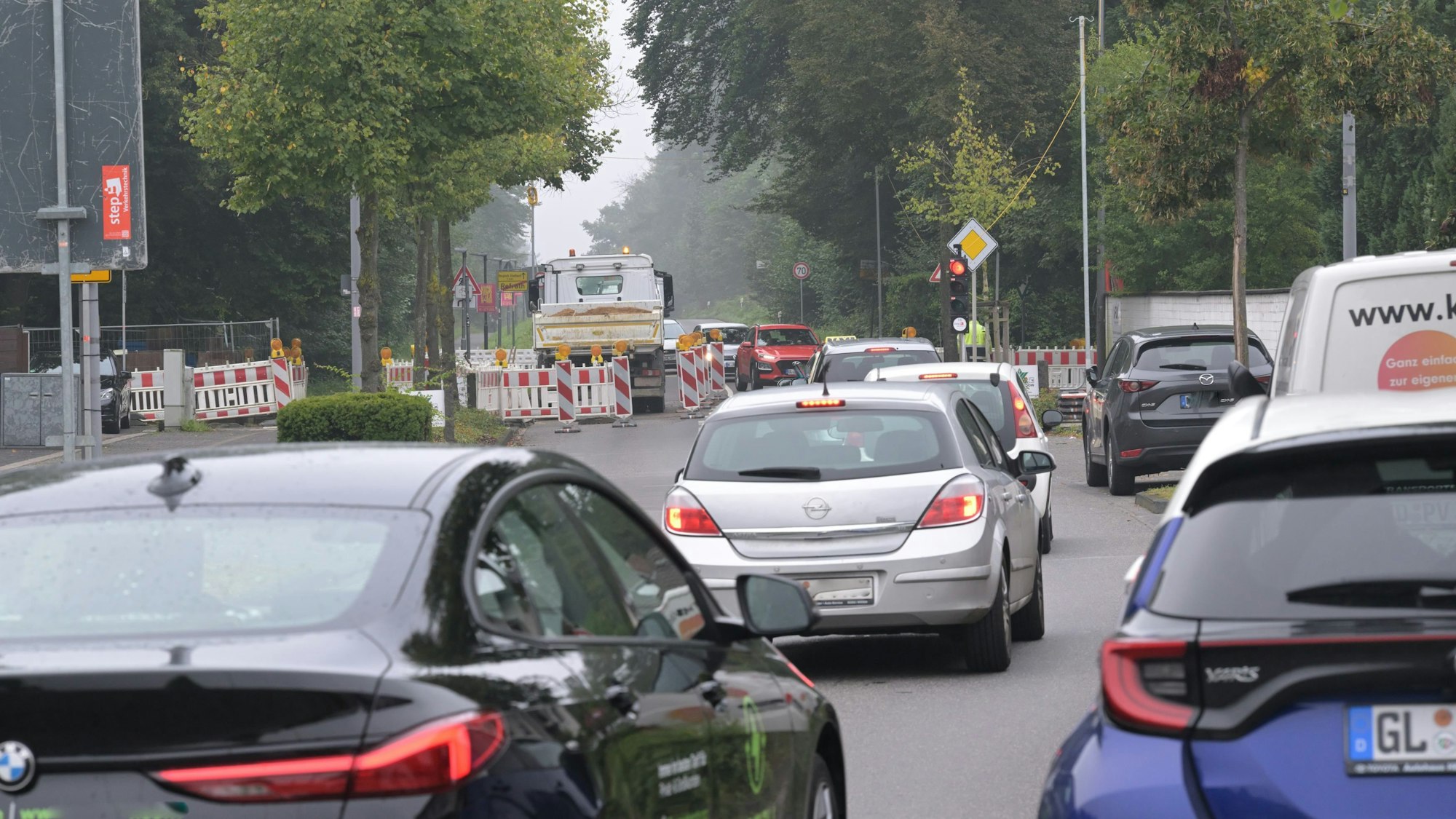 Vor der Baustellenampel stehen Autos im Stau.