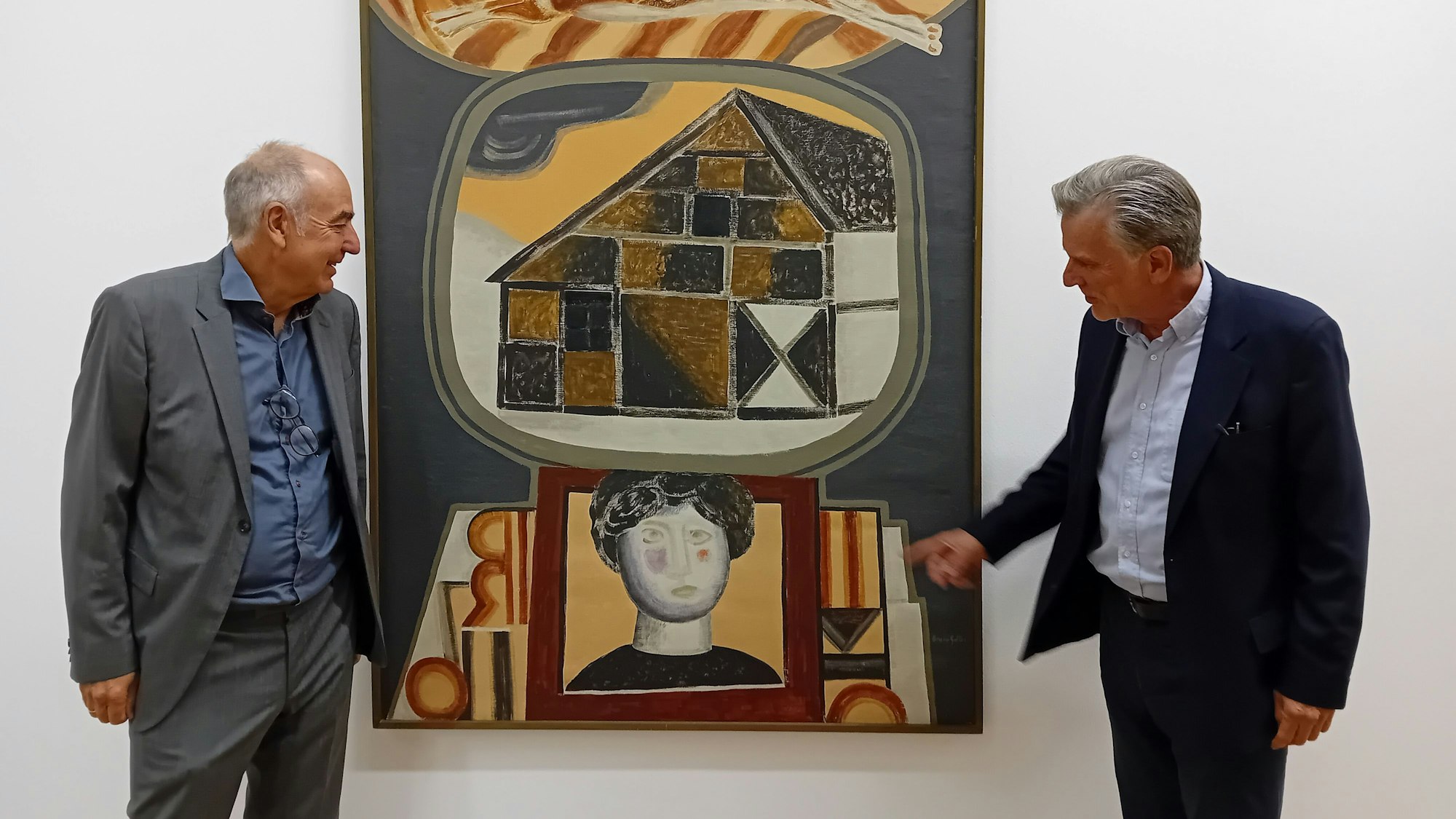 Zwei Herren stehen neben einem Bild mit Fachwerkhaus und Frauenkopf.