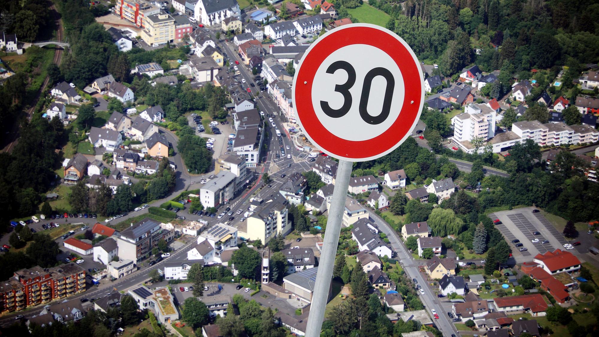 Ein 30 Schild als Fotomontage vor einer Luftaufnahme von Rösrath.
