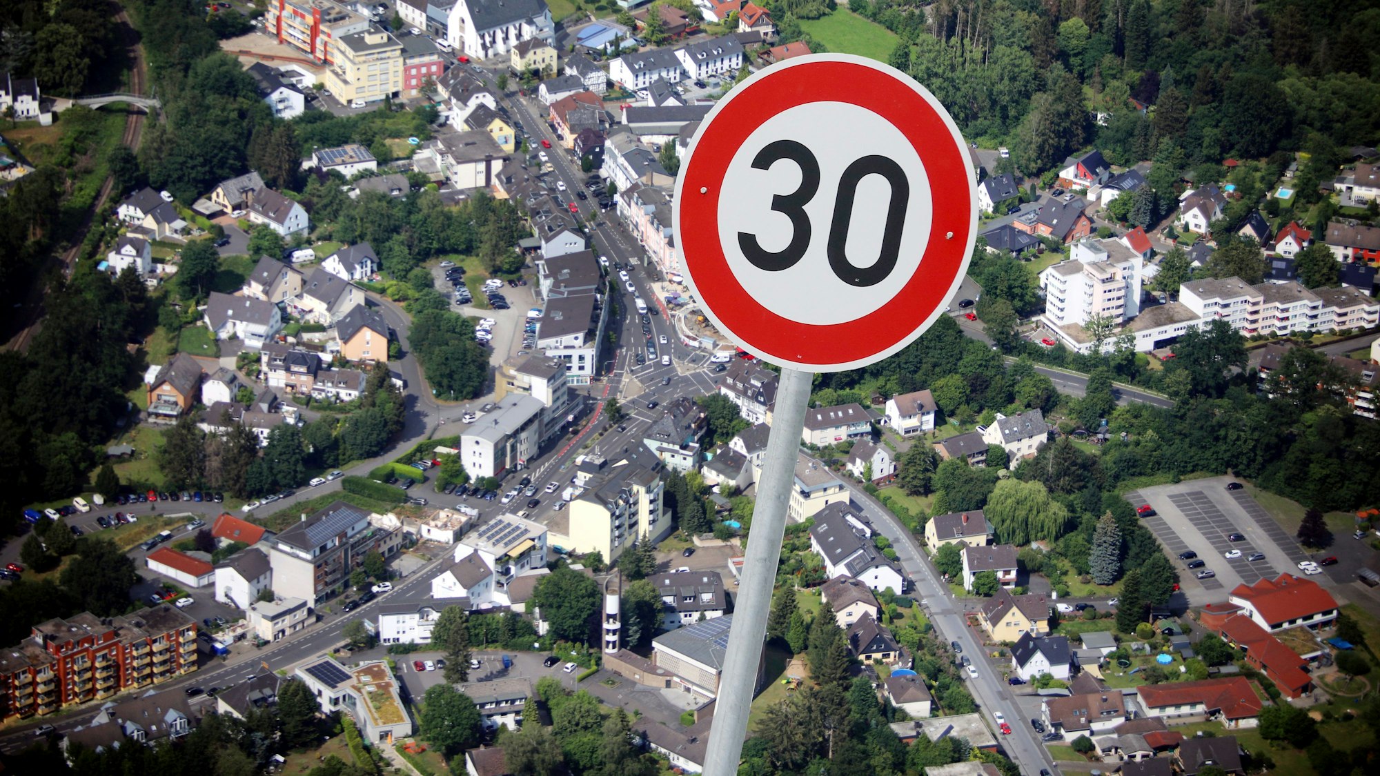 Ein 30 Schild als Fotomontage vor einer Luftaufnahme von Rösrath.