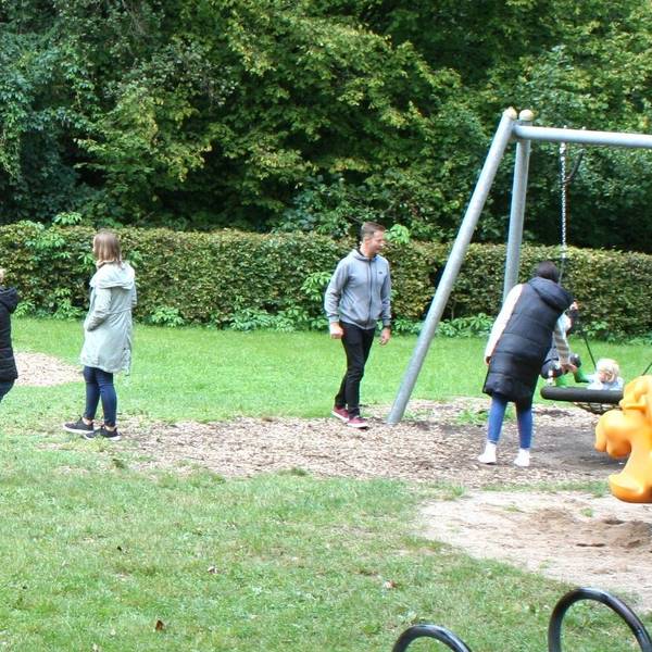 Kinder spielen an den Geräten auf einem Spielplatz.