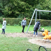 Kinder spielen an den Geräten auf einem Spielplatz.