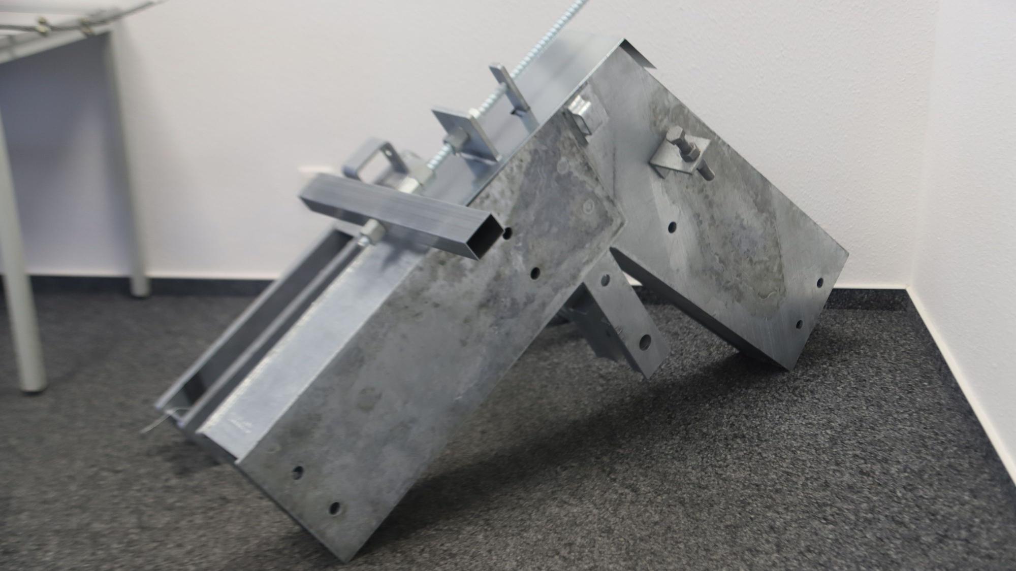 In der Ecke eines Raumes steht ein großer Stahlverbinder für den Hallenbau.