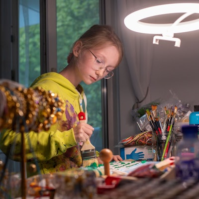 Die elfjährige Carolina Neubauer malt an einem Tisch in der Wohnung.