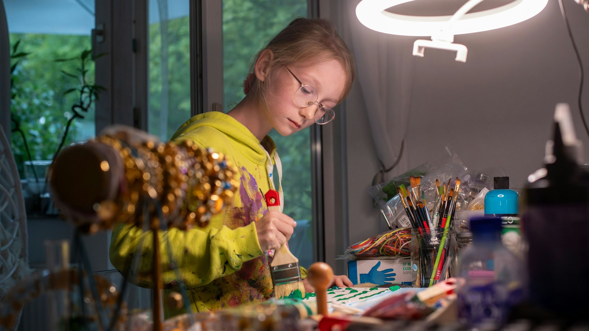 Die elfjährige Carolina Neubauer malt an einem Tisch in der Wohnung.