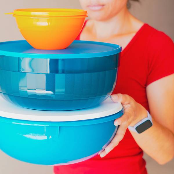 Eine Frau trägt luftdicht verschließbare Behälter von Tupperware.