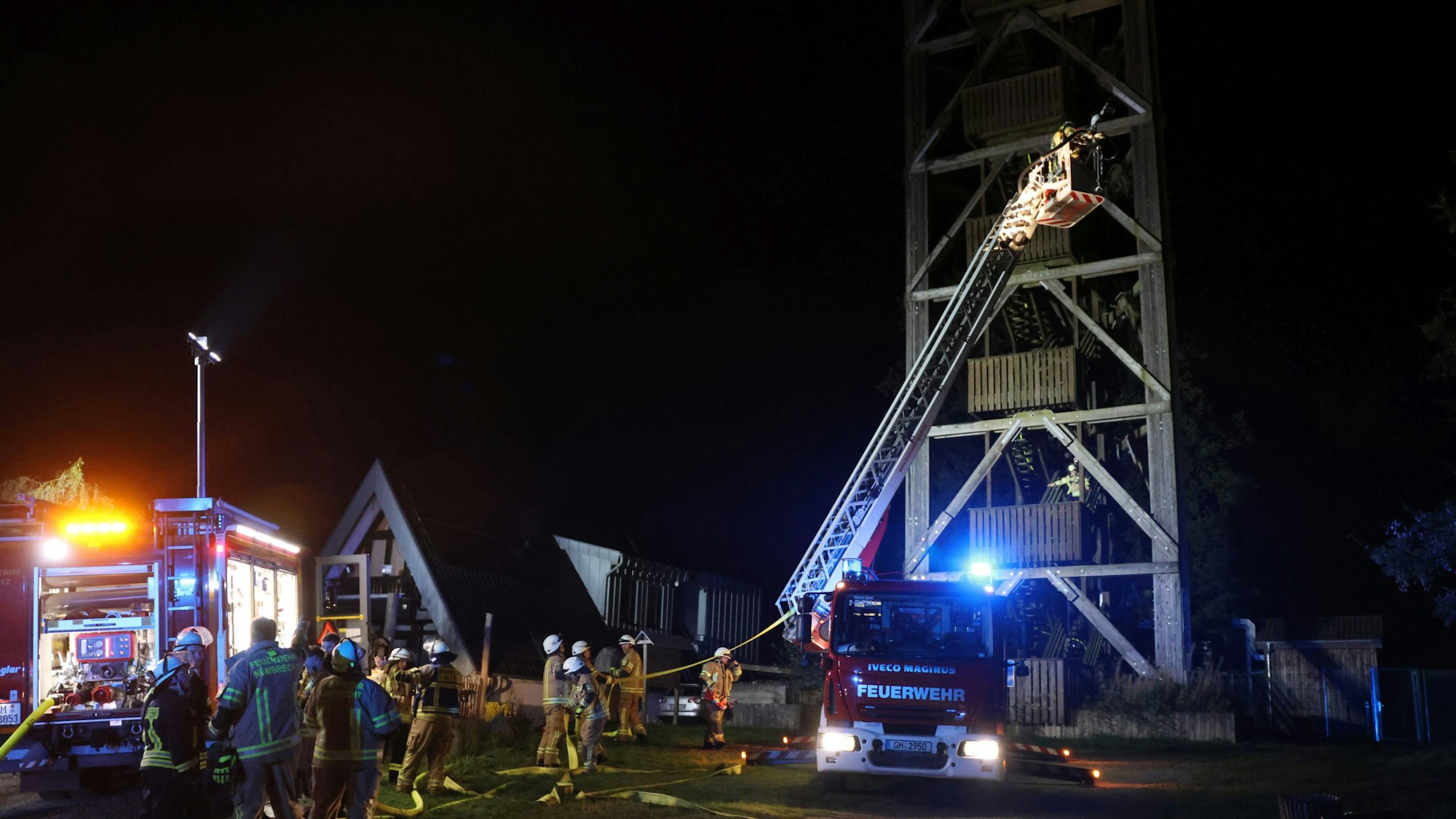 Vor dem Nümbrechter Aussichtsturm sind Einsatzfahrzeuge der Feuerwehr zu sehen, sie haben das Blaulicht eingeschaltet.